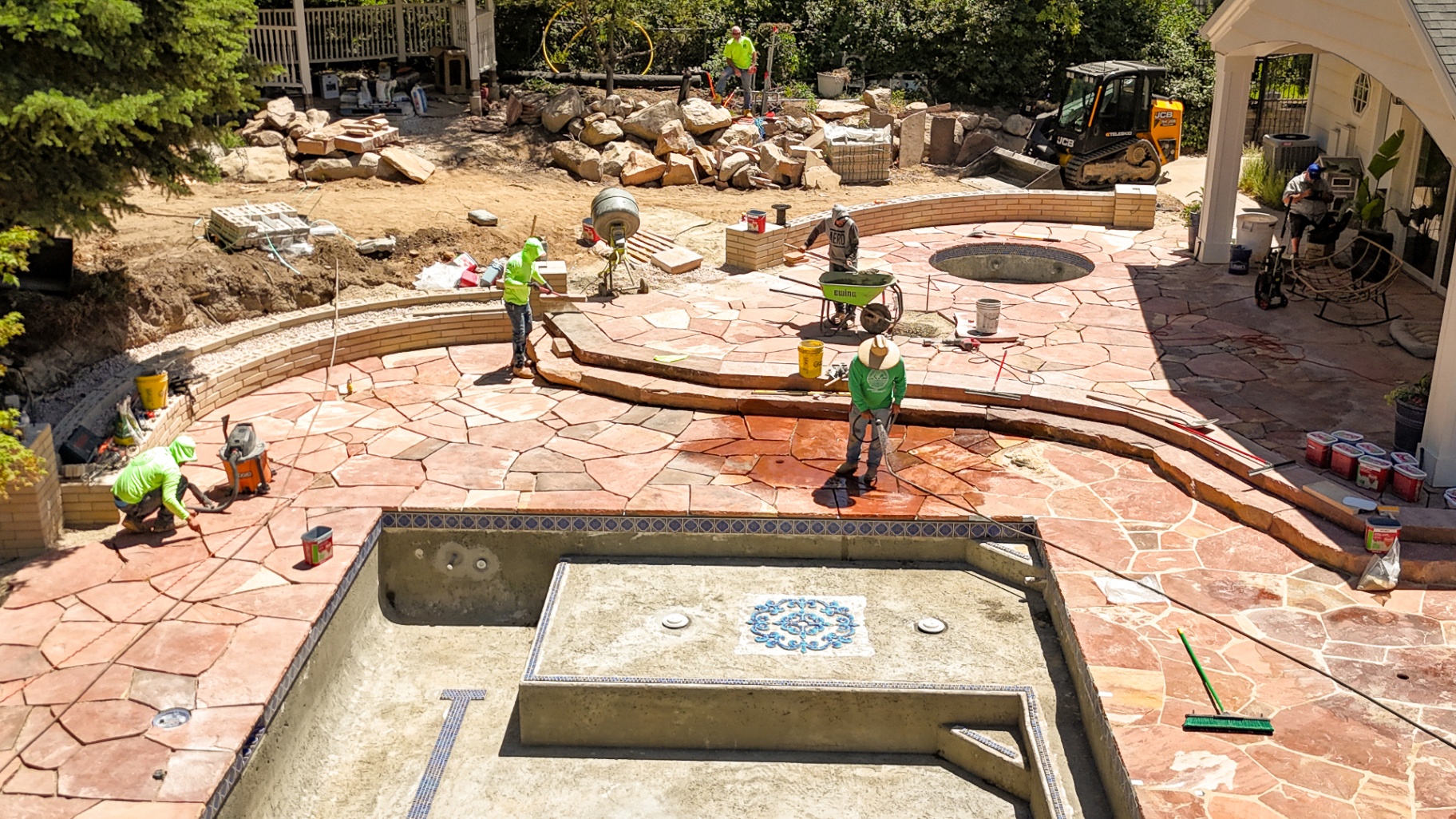 Crew laying flagstone around a custom pool
