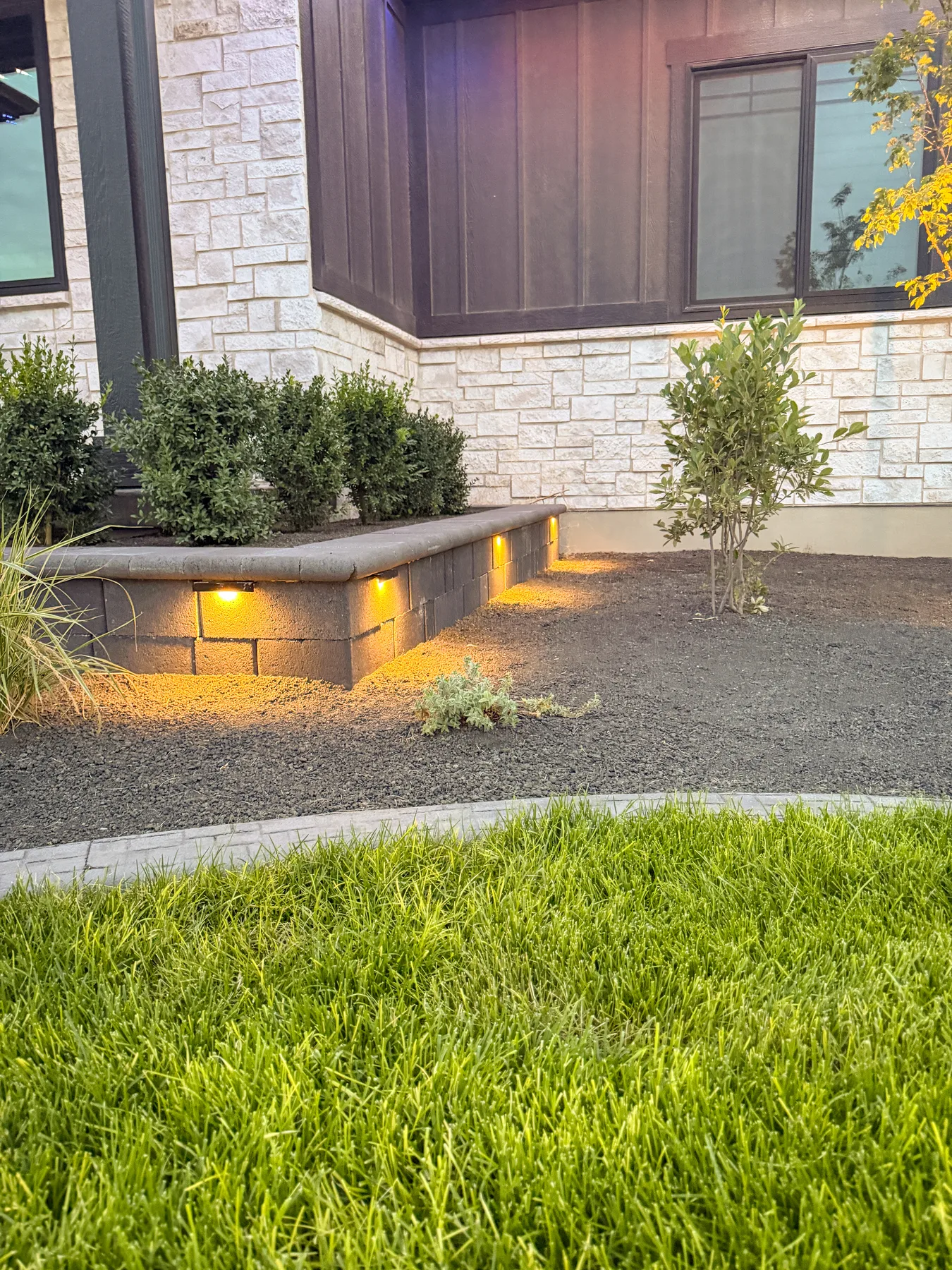 Low-voltage landscape lighting installation at dusk